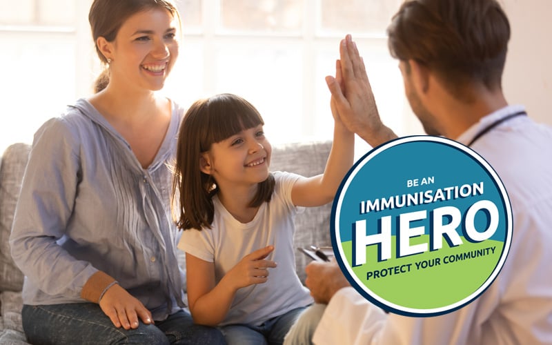 GP gives a young girl the high-five for being immunised